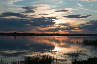 Bir rüzgar olmadan bir su birikintisi üzerinde çekici güzel günbatımı