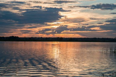 Bir rüzgar olmadan bir su birikintisi üzerinde çekici güzel günbatımı