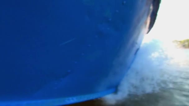 The hull of the blue boat on the left side, the movement along the river in good weather without large waves — Stock Video