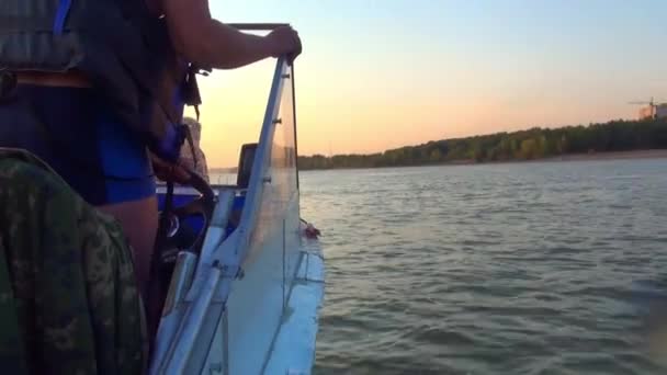 Zkušený kapitán malé lodi udržuje lodí po Vltavě při západu slunce — Stock video