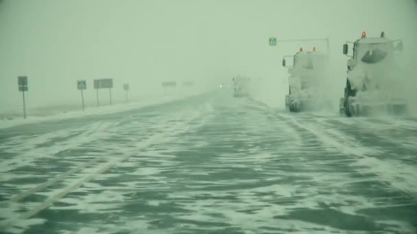 Förflyttning av bilen framåt på den snötäckta Siberian rutten i en ström av lastbilar, på byig laterala wind — Stockvideo