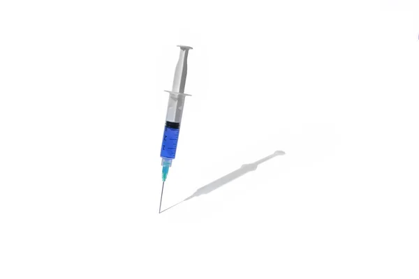 Seringue médicale avec médicament en bleu sur fond blanc avec une ombre — Photo