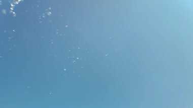 Mavi arka planda bir su sıçramasının yavaş hareketi