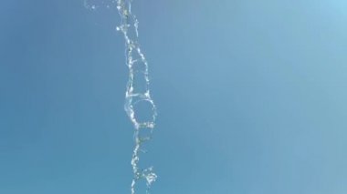 Mavi arka planda bir su sıçramasının yavaş hareketi