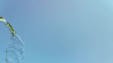 Mavi arka planda bir su sıçramasının yavaş hareketi