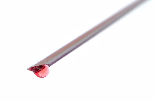 Détail de l'aiguille de seringue avec une goutte de sang isolé — Photo