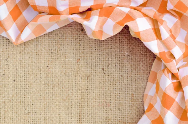 Oranje gevouwen geruite landelijke tafellaken over doek - frame — Stockfoto