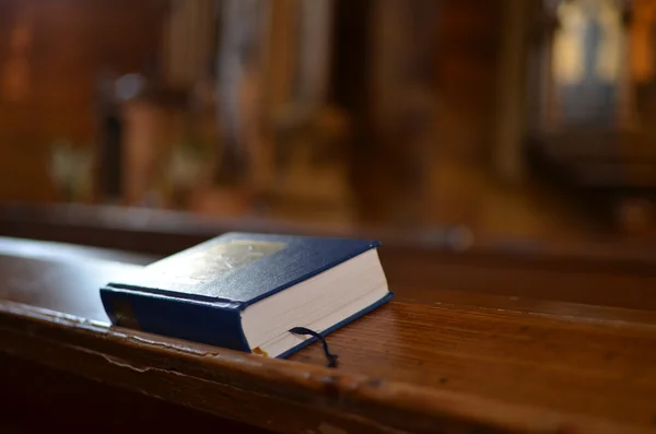 Santa Biblia yaciendo en un banco en la iglesia — Foto de Stock