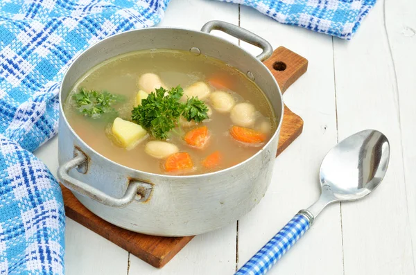 Фасолевый суп в старой жестянке, ковше, ложке и полотенце — стоковое фото