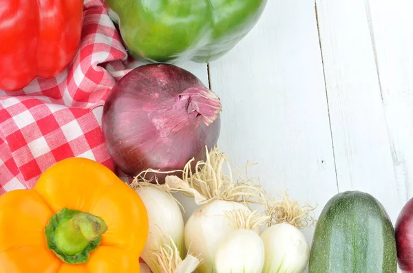 Перец, лук, цуккини, весенний лук и полотенце на столах — стоковое фото
