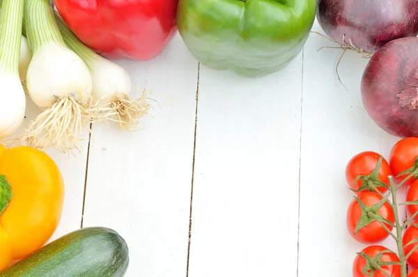 Здоровые свежие сельскохозяйственные овощи, такие как рамка на белом деревянном столе . — стоковое фото
