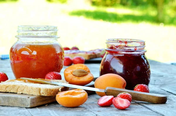 Jar of apricot and strawberry jam, fresh apricots and strawberries — Stock Photo, Image