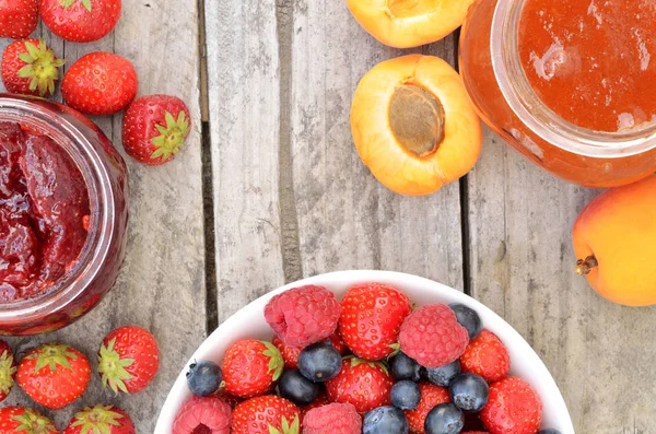 Чаша с ягодами фрукты, клубника и абрикосовые варенья — стоковое фото