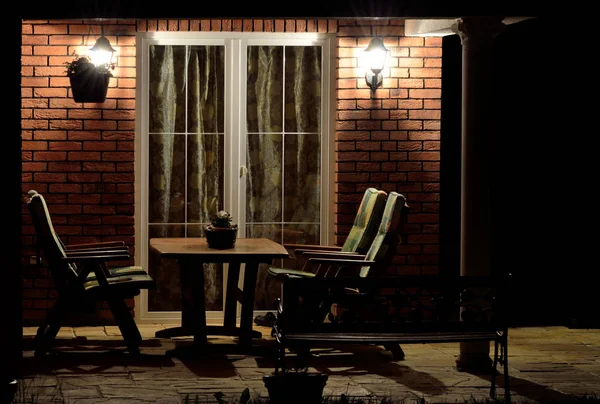 Modern house terrace (patio) with garden furniture at night