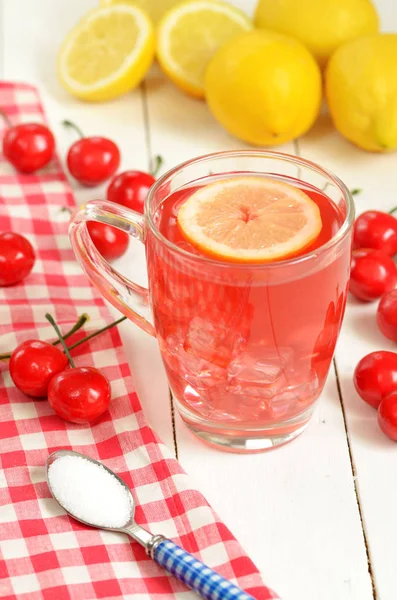 Τσάι φρούτων κεράσι με φέτα λεμονιού σε κούπα και τα κεράσια — Φωτογραφία Αρχείου
