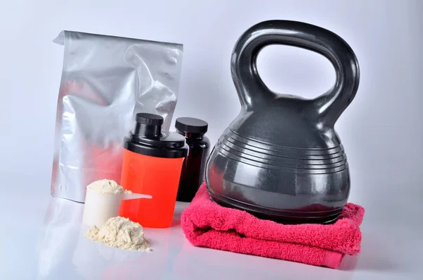 Envase de proteínas y polvo de proteínas, vitaminas, coctelera, toalla y kettlebell - concepto de fitness, aislado —  Fotos de Stock