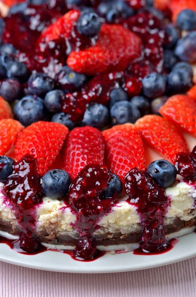 Torte mit frischen Erdbeeren, Blaubeeren und Kirschmarmelade. vertikales Foto. — Stockfoto