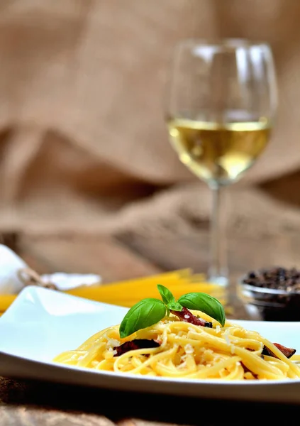Паста Алла Карбонара. Паста Спагетті Карбонара з беконом, пармезановим сиром, яйцем. Біле вино на фоні . — стокове фото