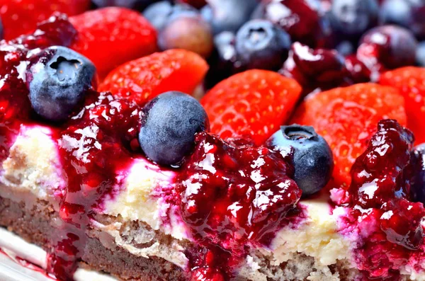 Makrodetail der Käsekuchentorte mit frischen Erdbeeren, Blaubeeren und Kirschmarmelade. — Stockfoto