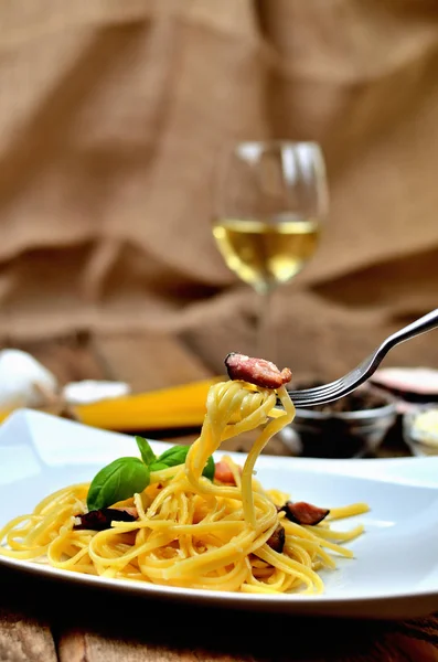 Pasta alla carbonara. Spaghetti Carbonara pasta, met spek, parmezaanse kaas, ei. Witte wijn op de achtergrond. — Stockfoto