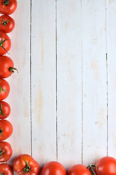 Tomates fraîches sur fond blanc rustique en bois. Vue de dessus. Espace de copie . — Photo