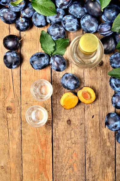 Shots of Slivovice, typical Eastern Europe alcohol plum brandy and bottle at background. View from above. Vertical photo. — Stock Photo, Image