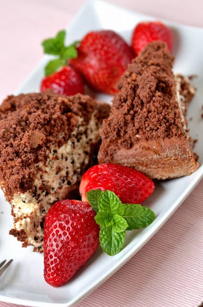 Homemade mole hole cake with whipped cream, banana, strawberries and fresh mint leaves on white decorative shaped plate. Pink place setting. Close-up. — Stock Photo, Image