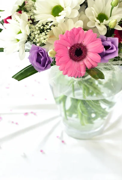 Buquê de casamento com flores roxas e rosa na toalha de mesa branca . — Fotografia de Stock