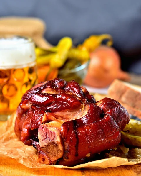Nudillo de cerdo asado con cerveza, mostaza, pepinillos y cuernos de cabra pimienta vegetal.. Foto vertical. Bodegón . — Foto de Stock