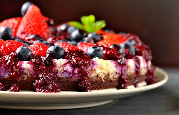 Cheesecake con fragole fresche, mirtilli e confettura di ciliegie. Bassa profondità di campo — Foto Stock