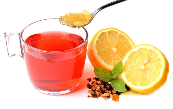 Taza de té de frutas, medio trozo de limón, un montón de té seco y cucharadita de miel aislada sobre fondo blanco . — Foto de Stock