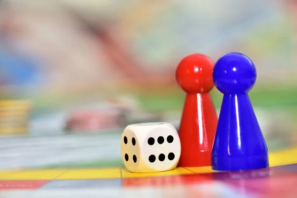 Blaue, rote Spielfiguren und Würfel im Brettspiel. — Stockfoto