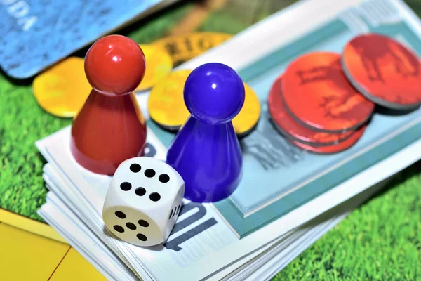 Dobbelstenen, blauwe, rode figuren, chips en spelgeld op het bord. — Stockfoto