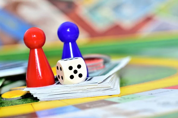 Close-up de azul, vermelho, amarelo jogar figuras e dados no jogo de tabuleiro. — Fotografia de Stock