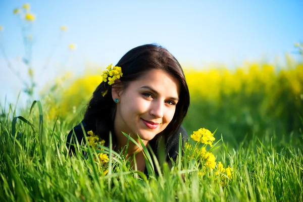 美丽的年轻长发女子躺在草丛中的肖像 — 图库照片
