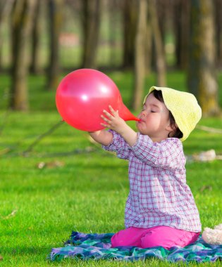 Küçük kız kırmızı şişirme balon açık havada