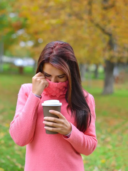 Retrato de bela jovem caucasiana, segurando taça de café takeaway, de pé no parque no outono — Fotografia de Stock