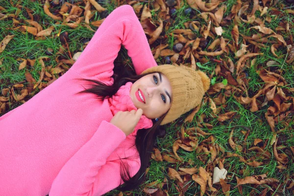 Mujer acostada sobre hojas de otoño, retrato al aire libre —  Fotos de Stock