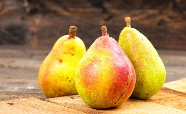 Pears on a rustic wooden kitchen table — Stock Photo, Image