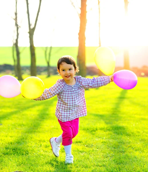 Menina com balões ao ar livre, dançando e apreciando a natureza — Fotografia de Stock