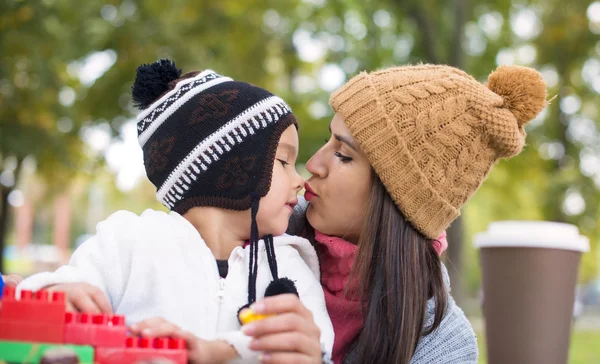 Mutter küsst ihre Tochter im Park — Stockfoto