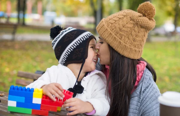 Mutter küsst ihre Tochter im Park — Stockfoto