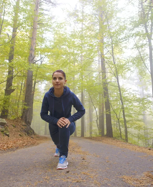 Mujer joven enérgica hacer ejercicios al aire libre en el parque para mantener sus cuerpos en forma — Foto de Stock