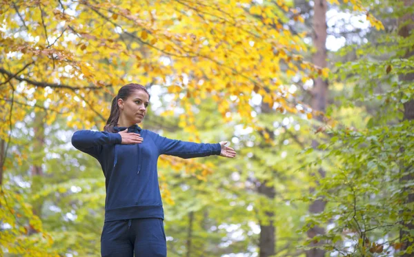 Mujer joven enérgica hacer ejercicios al aire libre en el parque para mantener sus cuerpos en forma — Foto de Stock