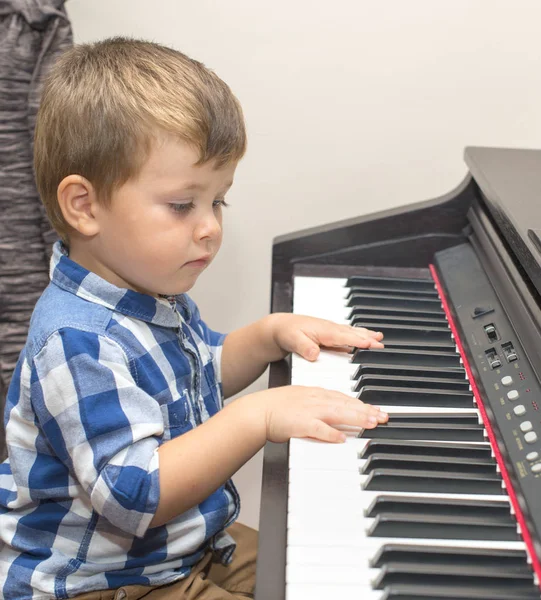 Gelukkig jongetje speelt piano thuis — Stockfoto