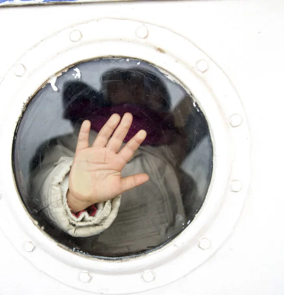 Foto av barn hand på ett fartyg vindow — Stockfoto