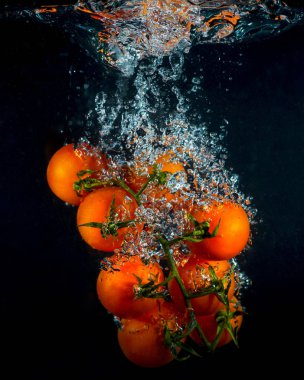 Siyah arka plan üzerine su sıçrama kiraz domates