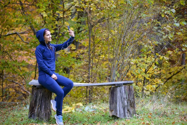 Ung brunett kvinna tar selfie i park. — Stockfoto