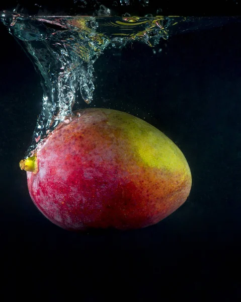 Spruzzi di mango in acqua su fondo nero — Foto Stock