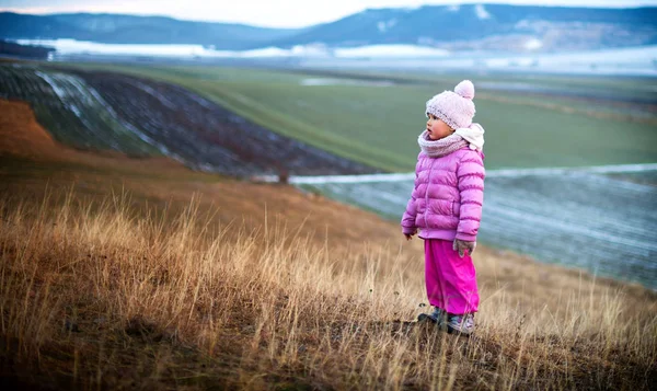 Porträtt av en liten flicka ensam i fältet. Vintertid — Stockfoto